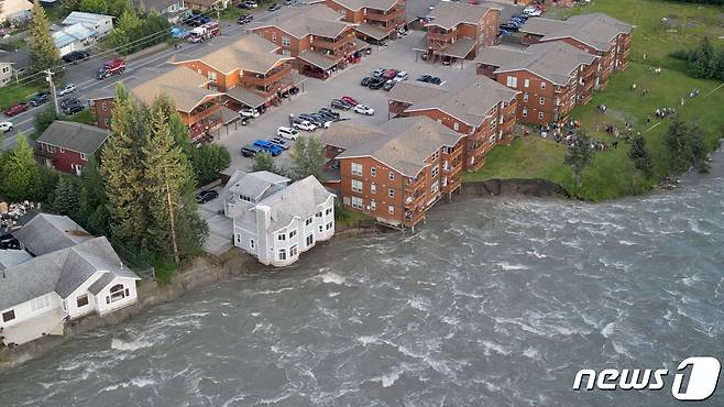 5일(현지시간) 알래스카 주노에서 빙하가 녹아 홍수가 발생하자 붕괴 직전인 강가의 집. ⓒ 로이터=뉴스1 ⓒ News1 박형기 기자