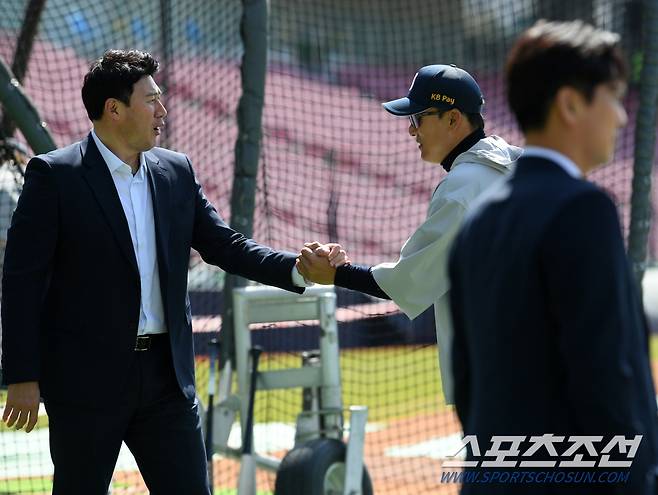 손을 맞잡고 정을 나누는 서재응 위원과 이승엽 감독