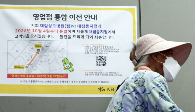 A sign at the entrance of a bank in Seoul, South Korea, announcing the move to consolidate branches. Yonhap News Agency