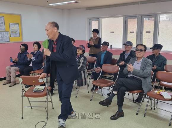 노인복지관에 있는 노래방에서 노래하고 손뼉 치며 즐거운 시간을 보내고 있는 노인들.