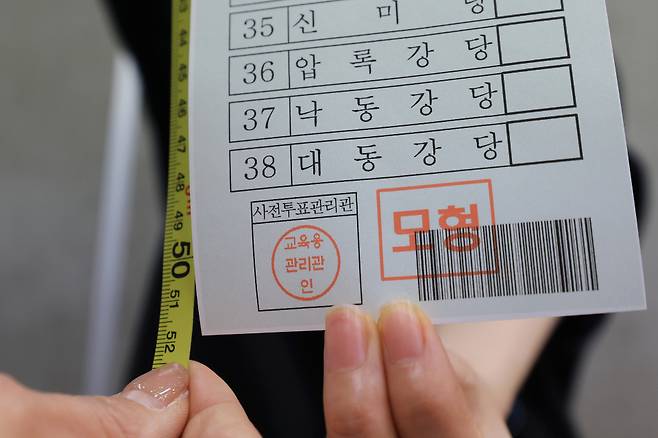 제22대 국회의원 선거를 14일 앞둔 3월27일 종로구 서울시선거관리위원회에서 직원이 비례대표 모의 투표용지를 들어 보이고 있다. 유권자들은 이번 총선에서 역대 가장 긴 51.7㎝에 달하는 비례대표 선거 투표용지를 받는다. ⓒ연합뉴스