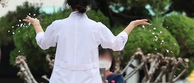 의정갈등이 계속되고 있는 4일 대구 한 대학병원에서 의료관계자가 벚꽃을 흩날리고 있다. 이날 박단 대한전공의협의회 비상대책위원장은 윤석열 대통령을 만나 면담할 예정이라고 밝혔다. [연합]