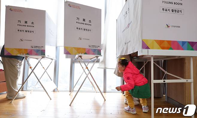 제22대 국회의원선거(총선) 사전투표 첫날인 5일 서울 영등포구 여의동주민센터에 마련된 제22대 국회의원선거 사전투표소에서 어머니가 딸과 함께 투표를 하고 있다. 2024.4.5/뉴스1 ⓒ News1 신웅수 기자