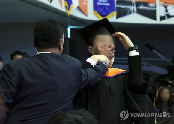 신민기씨가 지난 2월 KAIST 학위 수여식에서 윤석열 대통령에게 R&D 예산 삭감을 항의하다 경호원에게 끌려나가고 있다. - 연합뉴스