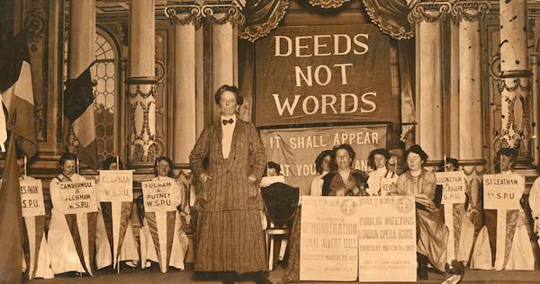 작곡가이자 여성 참정권 운동가였던 에델 스미스(Ethel Smyth)가 1912년 여성사회정치연합(WSPU) 집회에서 단상 위에 서 있다. 뒤로 'DEEDS NOT WORDS(말이 아닌 행동으로)'라는 구호가 적혀있다. 스미스가 투옥 중 작곡한 '여성들의 행진'은 WSPU의 주제가였다. 런던정치경제대학교(LSE) 도서관