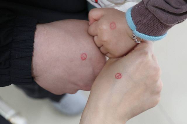 ▲ 제22대 국회의원선거 사전투표가 시작된 5일 오전 대구 달성군 유가읍 행정복지센터에 마련된 사전투표소에서 한 가족이 손등에 투표 도장을 찍어 인증사진을 남기고 있다. 연합뉴스