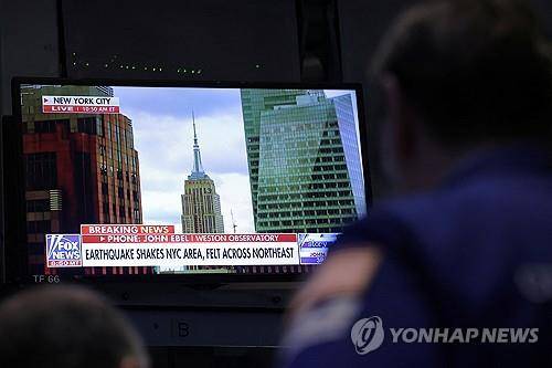 지진 발생 방송 지켜보는 뉴욕증권거래소 트레이더 [뉴욕 로이터=연합뉴스]