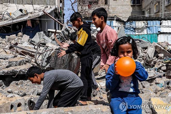 이스라엘군의 공습으로 무너진 건물 더미를 뒤지는 가자지구의 아이들 [AFP 연합뉴스 자료사진. 재판매 및 DB 금지]