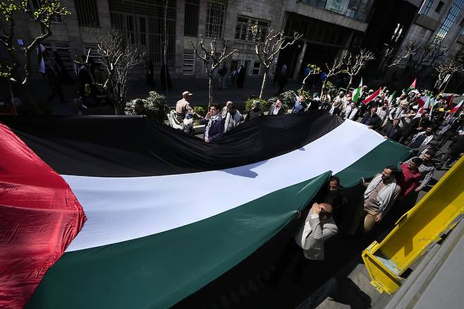 팔레스타인인 단결 집회를 기념하는 ‘쿠즈의 날(Quds Day)’이었던 지난 5일(현지시간) 이란 테헤란에서 이란 시민들이 팔레스타인기를 들고 있다. AP연합뉴스