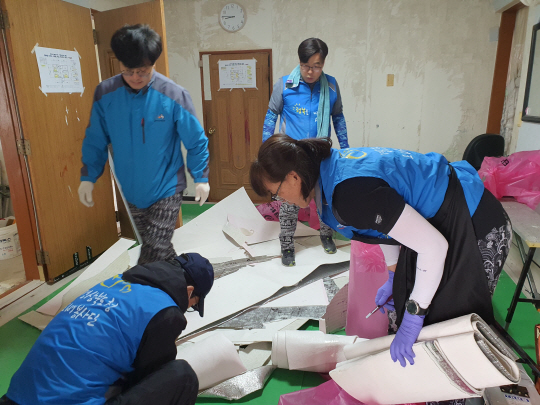 경북도청 공무원 봉사동아리 ‘행복을 바르는 사람들’ 회원들이 지난 6일 예천군 감천면 한 주택에서 도배를 하고 있다. 행복을 바르는 사람들 제공