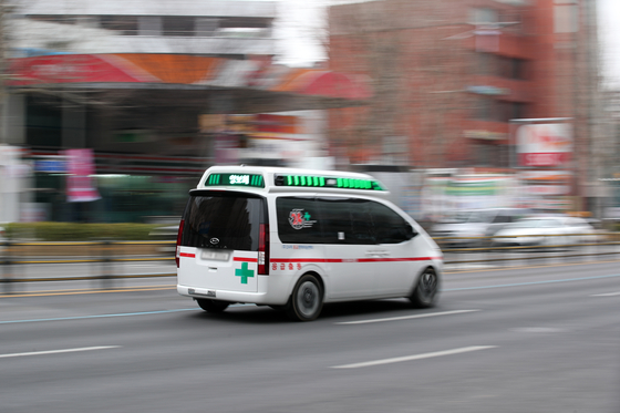 An ambulance drives by a university hospital in Seoul on Feb. 18. [NEWS1]