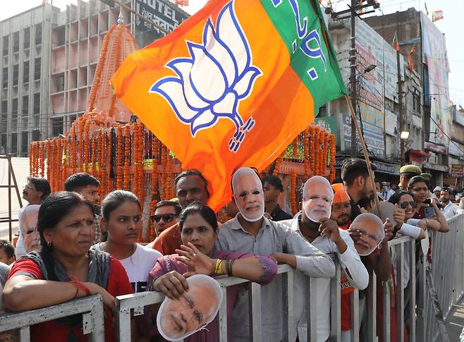 모디 마스크를 쓴 인도국민당(BJP) 지지자들이 지난 6일(현지시간) 인도 우타르프라데시주 가지아바드에서 다가오는 총선을 위해 선거운동을 하는 동안 BJP가 주최한 나렌드라 모디 인도 총리(보이지 않음)의 로드쇼를 지켜보고 있다. [EPA]