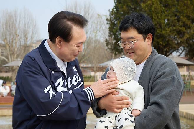 윤석열 대통령이 6일 오후 서울 용산어린이정원을 방문해 아기와 인사하고 있다. 대통령실 제공
