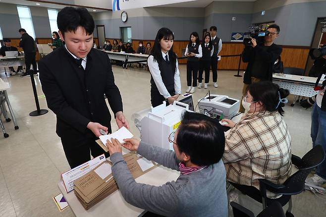 제22대 국회의원선거 사전투표가 시작된 5일 오후 삼일공업고등학교 학생들이 경기도 수원시 장안구 연무동행정복지센터에 마련된 사전투표소에서 투표용지를 받고 있다. 연합뉴스