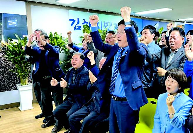 김정호 더불어민주당 김해을 후보가 10일 오후 경남 김해시 대청동에 마련한 자신의 선거사무소에서 방송 3사 출구조사 결과 보도를 보며 환호하고 있다.  연합뉴스