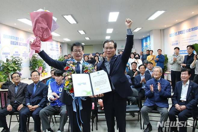 [음성=뉴시스] 22대 총선 충북 증평·진천·음성 선거구에 출마한 더불어민주당 임호선(왼쪽) 후보가 10일 오후 조병옥 음성군수로부터 당선축하증서를 받고 지지자들과 환호하고 있다. 2024.04.10. jyy@newsis.com