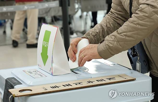 투표함에 투표지 넣는 유권자 [연합뉴스 자료사진]