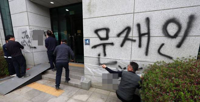 11일 오후 서울 서초동 서울고등검찰청 건물에 문재인 전 대통령과 서훈 전 국가정보원장을 비방하는 내용의 낙서를 하고 건물 창문에 돌을 던진 40대 남성이 경찰에 붙잡혔다. 사건 현장에서 청사 관계자들이 비닐막으로 낙서를 가리고 있다.(사진=뉴시스)