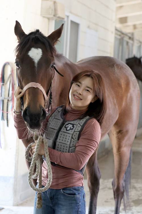 김혜선 기수가 부산 렛츠런파크에서 경주마 ‘광속마’와 사진 촬영하고 있다. [사진 = 한국마사회]