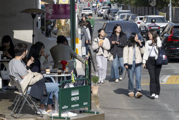 온화한 날씨를 보인 5일 해운대구 해리단길 카페거리를 찾은 시민들이 야외좌석에서 커피를 마시며 이야기를 나누고 있다. / 국제신문DB