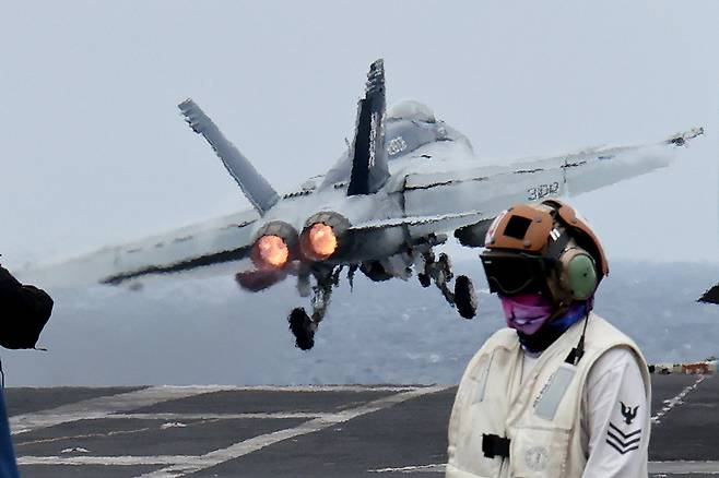 An F/A-18 Super Hornet fighter jet takes off from the deck of the US nuclear-powered aircraft carrier Theodore Roosevelt during a trilateral naval exercise with South Korea and Japan in the high seas south of Jeju Island on Thursday.