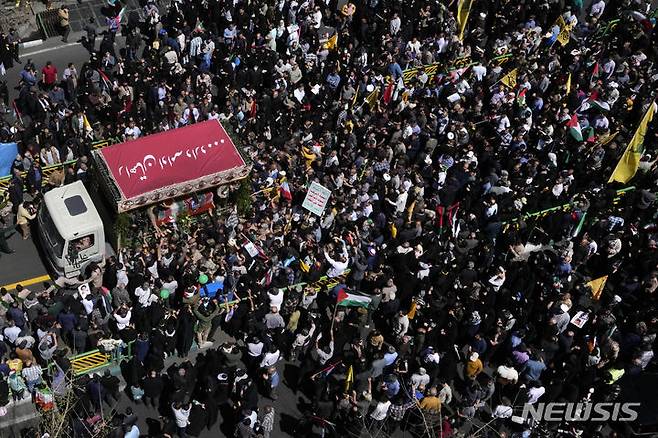 [테헤란(이란)=AP/뉴시스]지난 5일(현지시각) 이란 수도 테헤란에서 이스라엘의 다마스쿠스 주재 이란 영사관에 대한 공습으로 숨진 이란 혁명수비대원 7명에 대한 장례 행렬에서 수천명의 시위대원들이 혁명수비대 깃발로 더힌 사망자들의 관을 실은 트럭 주위에 모여 있다. 2024.04.14.
