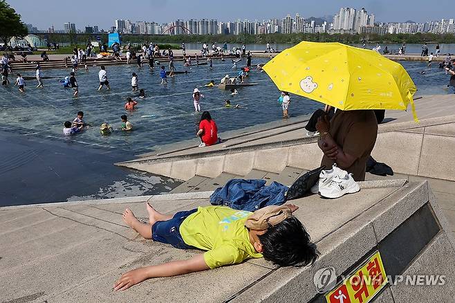 '잘 놀았다' (서울=연합뉴스) 서대연 기자 = 서울 한낮 기온이 29도까지 오르며 초여름 날씨를 보인 14일 오후 서울 영등포구 여의도한강공원 물빛광장에서 한 어린이가 물놀이를 마치고 몸을 말리고 있다. 2024.4.14 dwise@yna.co.kr