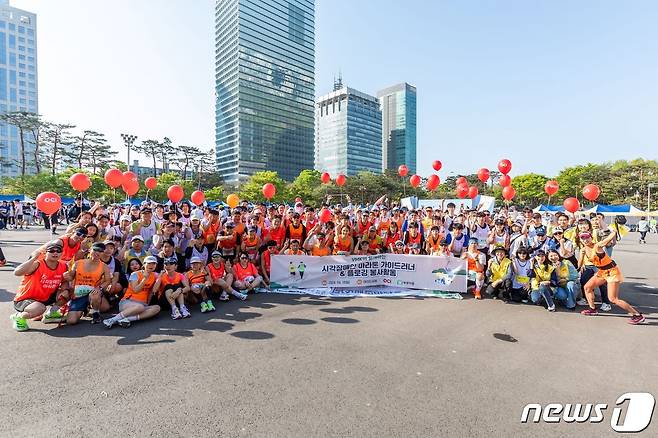 OCI홀딩스 임직원과 시각장애인 마라토너들이 완주 후 기념촬영을 하고 있다.(OCI홀딩스 제공)