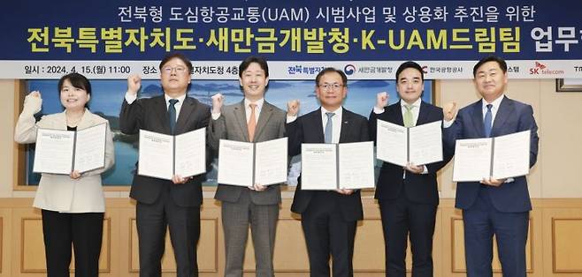 15일 전북특별자치도청에서 열린 '전북형 UAM사업 업무협약 체결식' 에서 관계자들이 협약체결 후 기념촬영을 하고 있다. 왼쪽부터 윤순희 새만금개발청 차장, 김정호 한화시스템 사업대표, 윤형중 한국공항공사 사장, 하민용 SK텔레콤 최고사업개발책임자(CDO), 박서하 티앱모빌리티 부사장, 김관영 전북특별자치도지사.(사진제공=한국공항공사)