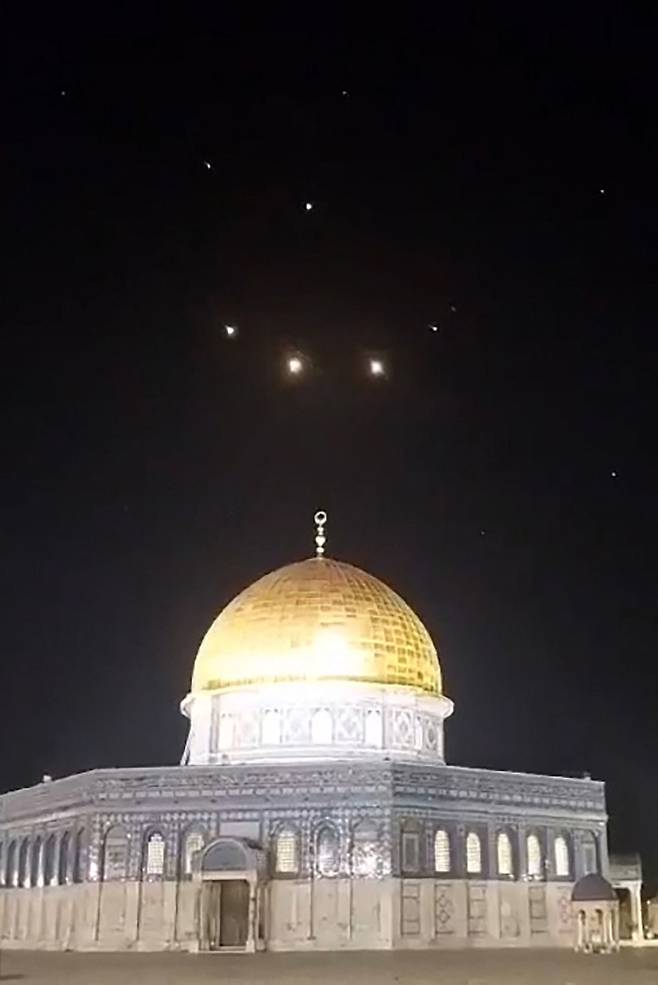 예루살렘의 알아크사 모스크 위 하늘 위로 14일(현지 시각) 이란이 발사한 드론과 미사일을 방어하기 위한 로켓 흔적이 보인다. / AFP 연합뉴스