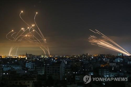 2021년 이스라엘-하마스 11일 전쟁 당시 가자지구에서 발사된 로켓(오른쪽)과 이를 요격하기 위해 발사된 아이언돔 미사일(왼쪽)의 궤적. 기사 내용과 직접 관련 없음.  [사진 제공=AFP 연합뉴스]