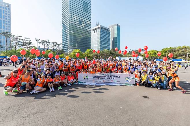 OCI홀딩스 임직원과 시각장애인이 지난 14일 여의도 한강공원에서 마라톤대회 완주 후 기념촬영을 하고 있다. [OCI홀딩스 제공]