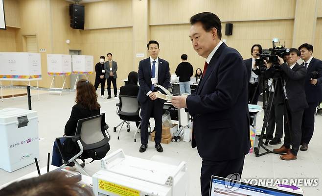 사전투표 용지 받는 윤석열 대통령 (부산=연합뉴스) 진성철 기자 = 윤석열 대통령이 제22대 국회의원선거 사전투표가 시작된 5일 부산 강서구 명지1동 행정복지센터 사전투표소에서 선거사무원에게서 사전투표용지를 받고 있다.  2024.4.5  [대통령실통신사진기자단] zjin@yna.co.kr