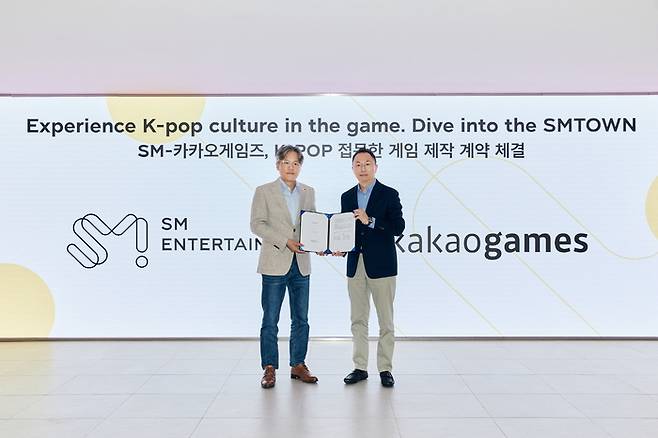 카카오게임즈와 SM엔터테인먼트 K팝을 접목한 게임 제작을 위해 지식재산(IP) 라이선스 계약을 체결했다. 장철혁 SM엔터테인먼트 대표(왼쪽)와 한상우 카카오게임즈 대표가 기념촬영했다.