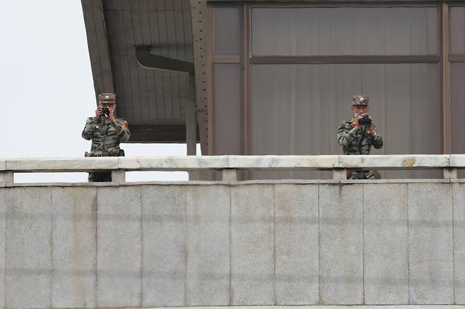 북한 판문각 3층에서 군인들이 망원경과 카메라를 들고 밖으로 나오고 있다. 김혜윤 기자