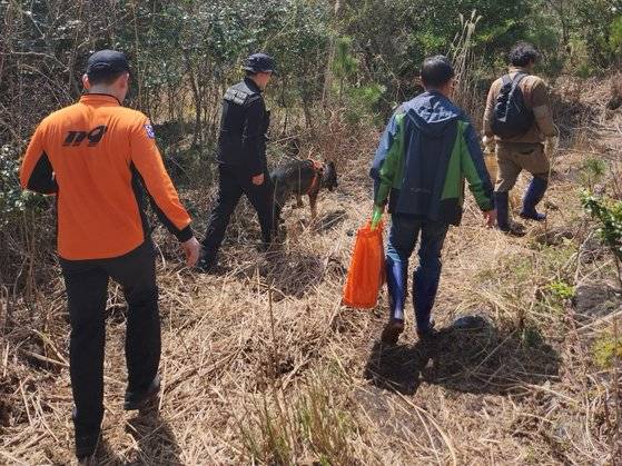 지난달 29일 제주시 구좌읍 덕천리에서 119에 구조된 고사리 채취객이 구조대원과 수풀을 빠져 나가고 있다. [사진 제주도소방안전본부]