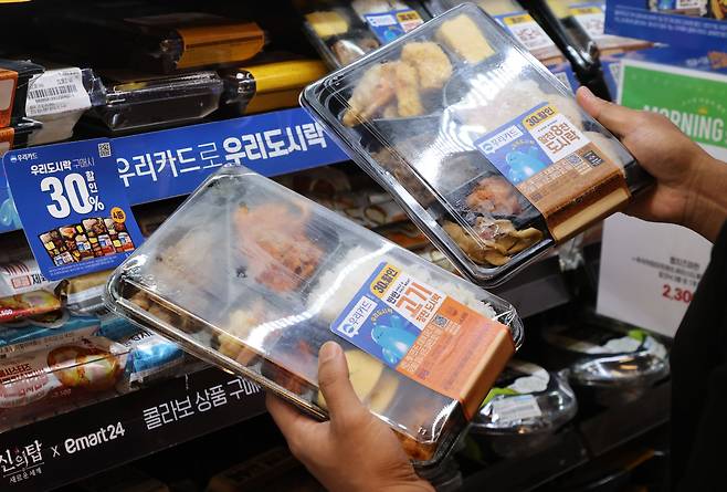 서울 시내 한 편의점 직원이 판매 중인 도시락을 들어 보이고 있다. /연합뉴스