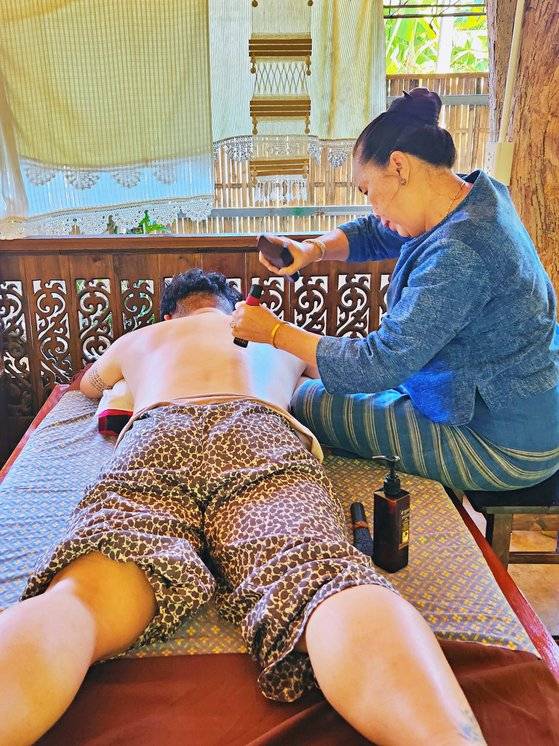 타마린드 나무로 만든 망치로 몸을 두드리는 톡센 마사지. 마스터의 손길로 오십견을 고칠 수 있었다. 사진 김은덕, 백종민