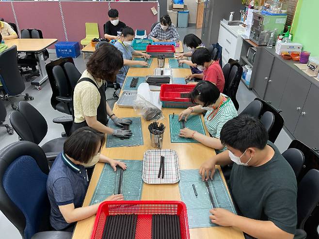 직업재활팀이 커피 찌꺼기를 활용해 연필을 만들고 있는 모습