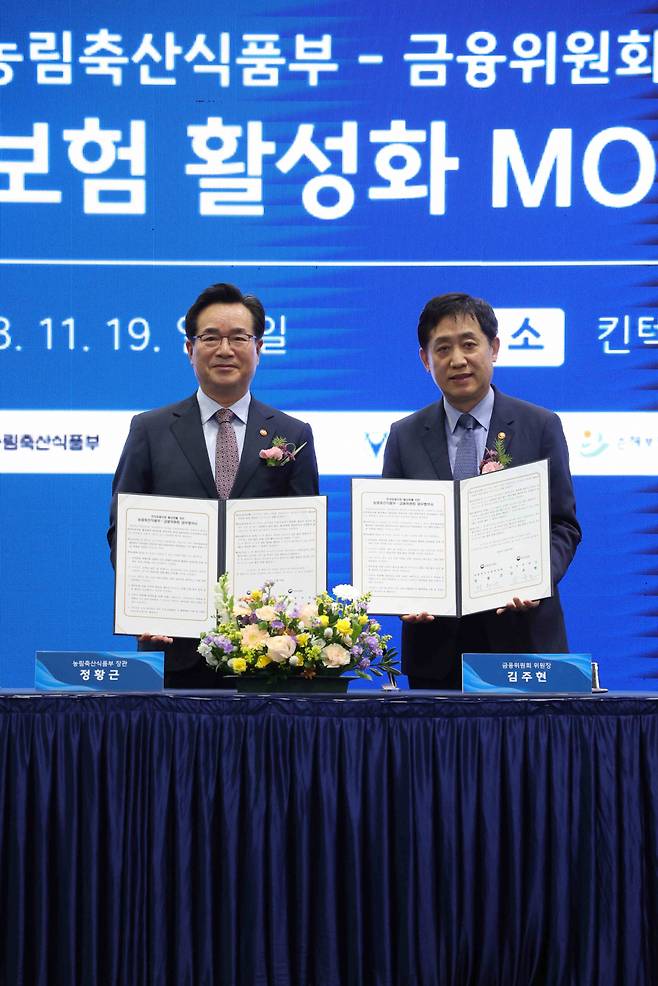 지난해 11월19일 당시 정황근 농림수산축산식품부 장관(왼쪽)과 김주현 금융위원장이 경기도 고양시 킨텍스에서 열린 농림축산식품부-금융위원회 반려동물보험 활성화 업무협약 체결식에서 서명 후 기념촬영하고 있다. ⓒ연합뉴스