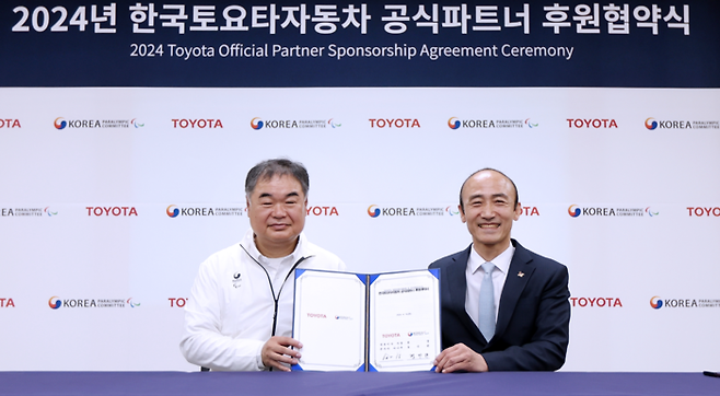 한국토요타자동차 콘야마 마나부 대표이사와 대한장애인체육회 정진완 회장이 협역서를 들어보이고 있다.