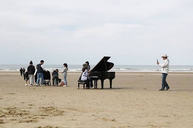자은도 양산해변을 찾은 관광객들이 피아노 포토존에서 사진을 찍고 있다. [사진제공=신안군]