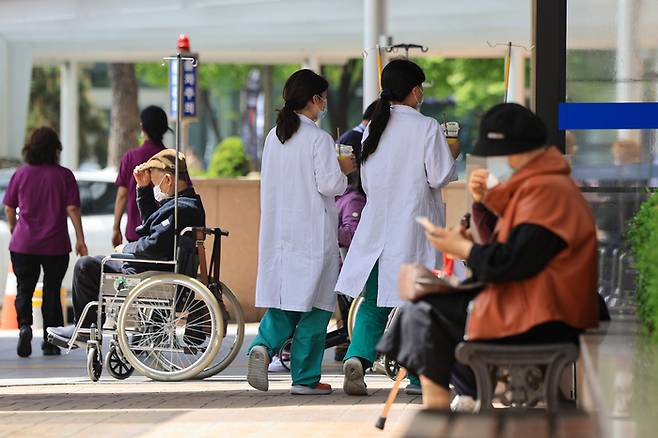 정부의 의대 증원 추진에 반발한 전공의들이 병원을 떠난지 60일째인 18일 서울 시내 한 대학병원에서 의료진이 이동하고 있다. | 연합뉴스