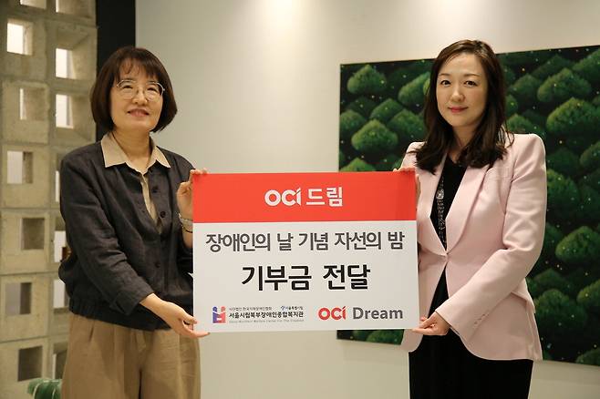 지난 18일 자선행사에서 이지현 OCI드림 대표(오른쪽)가 서울시립 북부장애인종합복지관에 기부금을 전달하고 있다.  OCI