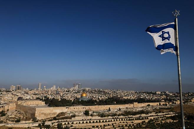 19일(현지시간) 예루살렘의 알 아크사 모스크 단지와 도시 스카이라인이 내려다보이는 올리브 산에 이스라엘 국기가 휘날리고 있다. [AFP]