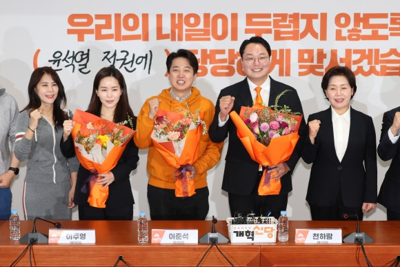 ]개혁신당 이준석 대표와 이주영·천하람 총괄선대위원장이 11일 국회에서 열린 개혁신당 중앙선거대책위원회 해단식에서 국회의원 당선 축하 꽃다발을 받은 뒤 포즈를 취하고 있다. 연합뉴스