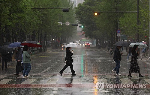 비가 내린 15일 오전 서울 영등포구 여의도역 인근에서 시민들이 우산을 쓰고 이동하고 있다. [연합뉴스]