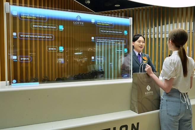 외국인 쇼핑객이 롯데백화점 잠실점 AI 통역 서비스를 이용하고 있다.