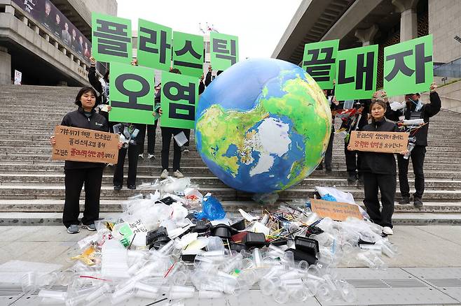 지구의 날인 22일 오전 서울 광화문광장 세종문화회관 앞에서 녹색연합 회원들이 플라스틱 생산 감축을 촉구하는 퍼포먼스를 하고 있다. 연합뉴스
