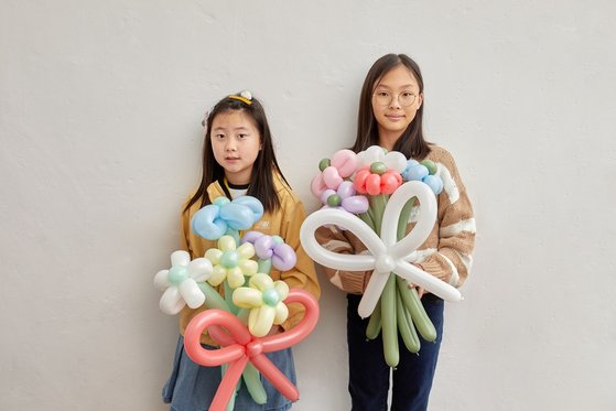윤근혜(왼쪽) 학생모델·정하은 학생기자가 풍선아트에 대해 알아보고, 요술풍선을 이용해 예쁜 꽃다발을 만들었다.